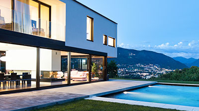 A modern Cubist house with a pool and mountains in the background