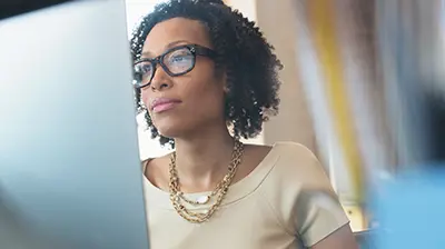 Woman dressed in business casual attire on desktop computer.