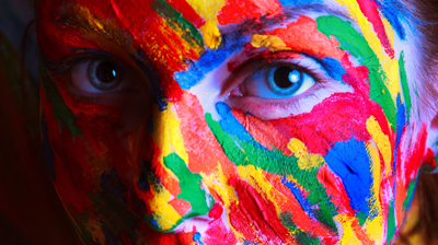 A close up shot of a woman's face with colorful face paint on 