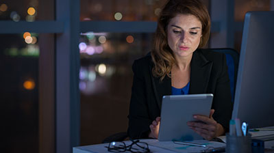 A woman using a tablet at night in the office