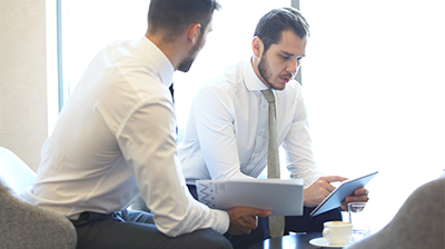 Two business men working on a project on a tablet
