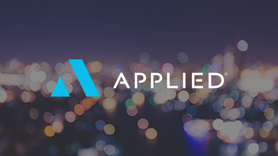 The Applied Systems logo with the word "Applied" next to it in front of a blurred background of a city at nighttime 