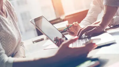 Group of people actively working on a laptop