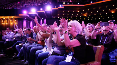 Applied Net attendees cheering at a keynote session.