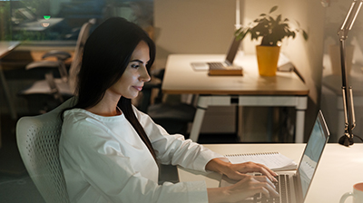 A young businesswoman sitting at a desk while working on her laptop