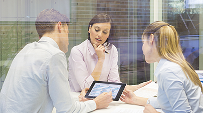 A man and two women working together with a tablet
