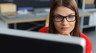 Young woman with glasses looking at computer