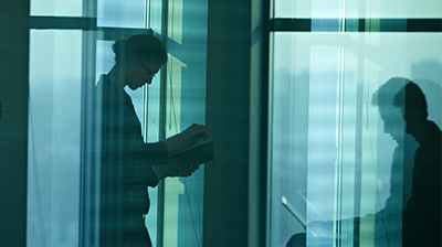 Silhouettes of two people working in the office