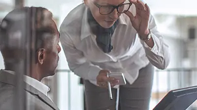 A businessman showing a businesswoman something on his computer screen