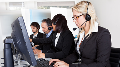 A group of customer support representatives. A young businesswoman is the focal point