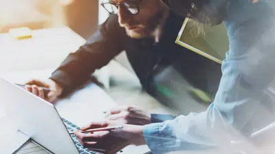 Two people working together on a laptop