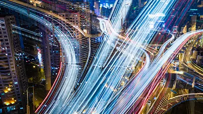 Neon light traces going in different directions at night in a city