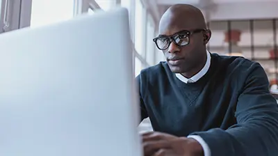 A young business man working at a laptop computer